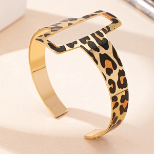 Fashionable golden open bangle featuring leopard print pattern and geometric rectangular cutout
