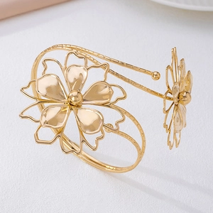 Primer plano del brazalete de brazo floral dorado con acabado texturizado y pétalos