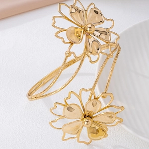 Elegante brazalete abierto dorado con motivos florales huecos y macizos de estilo vintage