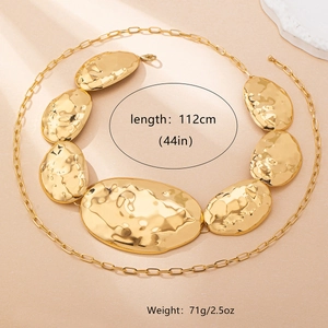 Detailed view of irregular golden hammered metal plates on a long chunky waist chain