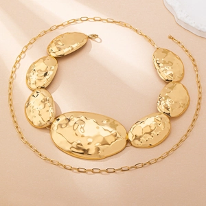 Detail of irregular gold hammered metal plates on a trendy geometric waist chain