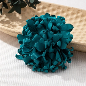 Handgefertigte dunkelgrüne Stoffblumen-Brosche mit Schichtblättern auf einem Tablett