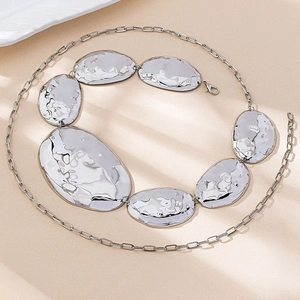 Close-up of silver irregular hammered metal plates on a stylish geometric waist chain