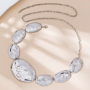 Detail of silver irregular geometric waist chain with textured hammered finish links