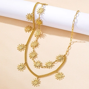 Detail of layered gold waist chain featuring sun god face pendants and Cuban link style