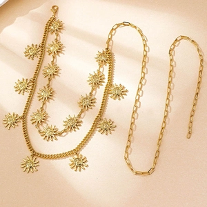 Detailed macro view of gold-plated sun-face charms on multilayered body chain jewelry