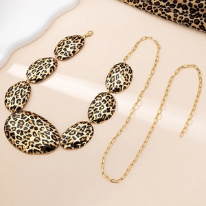Macro shot of oversized leopard print oval pendants on a gold-tone chunky statement chain