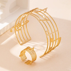 Set di gioielli dorati con bracciale e anello regolabile con motivi a note musicali