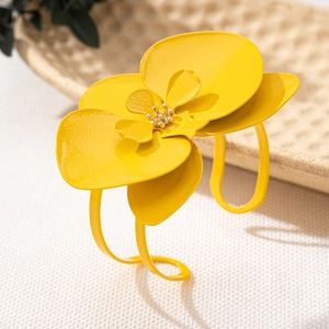 Detailansicht eines leuchtend gelben Emaille-Blumen-Armreifs mit goldenem Staubblatt