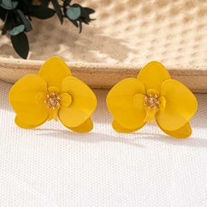 Makroaufnahme von leuchtend gelben Ohrsteckern in Orchideenform mit floralen Details
