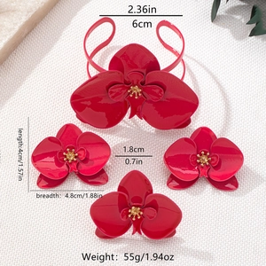Makroaufnahme eines roten Orchideen-Schmucksets mit Armreif und passenden Accessoires