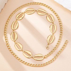 Close-up of golden bohemian waist chain with detailed seashell charms and lobster clasp