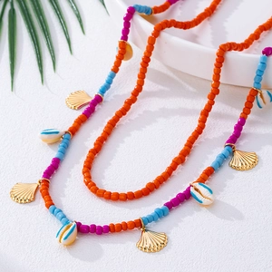 Detail der bunten Perlen-Taillenkette mit goldenen Muschel-Anhängern im Strand-Stil