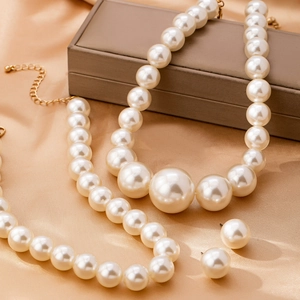 Set vintage francese di collana e orecchini di perle su elegante sfondo di raso beige
