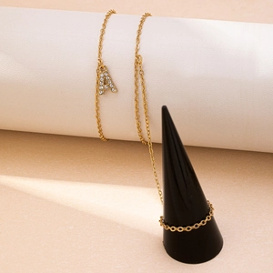 Élégant bracelet lettre A dorée avec strass scintillants sur un présentoir chic