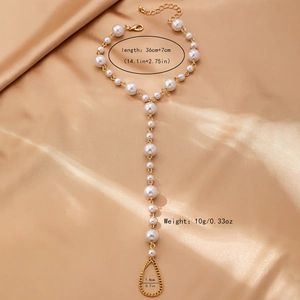 Detailed view of Baroque pearl toe anklet chain with size specifications on gold silk fabric