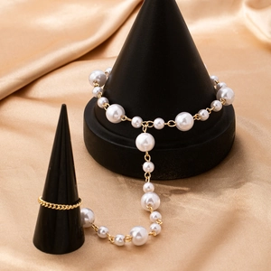 Baroque pearl toe ring anklet with gold chain shown on a luxurious silk background