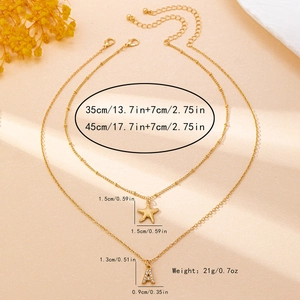Dettaglio della collana a due strati dorata con pendente a lettera A e stella marina in strass