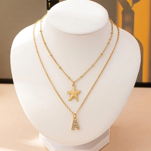 Elegante collana doppia dorata con ciondolo a stella marina e lettera A con strass