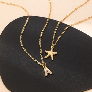 Collana a doppio strato dorata con ciondolo a stella marina e lettera A con strass lucidi