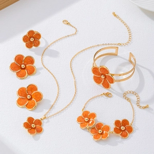 Détail de la parure de bijoux à cinq pièces avec fleurs en émail orange et collier