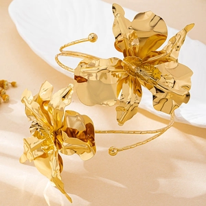 Detailed close-up of golden metallic 3D flower arm cuff bracelet with polished petals
