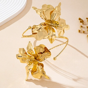 Exaggerated gold metal iris flower arm cuff featuring irregular floral texture and shiny finish
