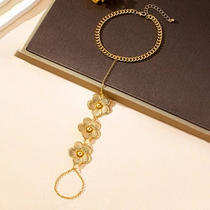 Vue détaillée d'un bracelet de main doré vintage avec des fleurs évidées et chaîne cubaine