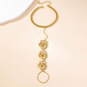 Détail du bracelet bague fleur dorée avec chaîne à maillons et anneau réglable