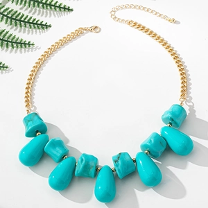 Detail of bohemian gold chain necklace with turquoise resin charms and lobster clasp