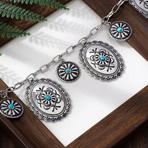 Dettaglio della catena boho argento con ciondoli a fiori turchesi e dischi in metallo