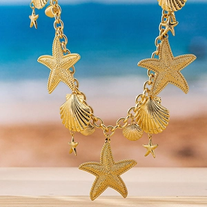 Detail of golden sea theme waist chain with textured starfish and seashell pendants