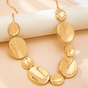 Macro shot of polished gold ocean style metal disks and shell pendants detail