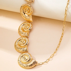 Detailed macro view of golden seashell pendants and paperclip chain link texture