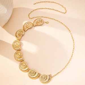 Detailed view of golden seashell nautilus charms and modern paperclip chain link belt