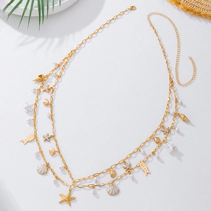 Detail of gold double-layered waist chain with sea shells, starfish and pearls