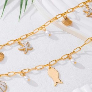 Detailed macro view of ocean-themed waist chain with starfish, shells, and pearls