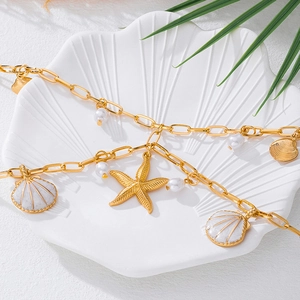 Detailed shot of ocean theme belt with gold starfish, seashell charms and white pearls