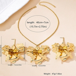 Detail view of large gold metallic flower necklace and earrings set with measurements