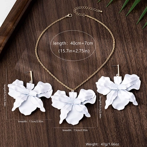 Detailed view of oversized white flower necklace and earrings with precise measurements