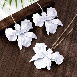 Detailed close-up of white floral jewelry set including earrings and matching necklace