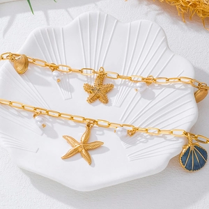 Detail of gold starfish and shell charms with pearls on a nautical waist chain