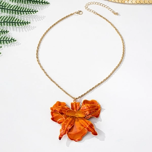Detailed view of the orange floral orchid pendant with a gold chain and lobster clasp