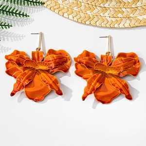 Detail of vibrant orange gradient orchid drop earrings with a tropical vacation style