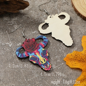 Detail of bohemian cow skull wood earrings with floral patterns and size specifications