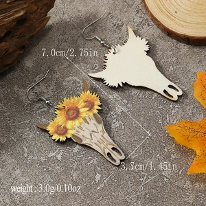 Detail of sunflower cow skull wooden earrings with size markings on stone background