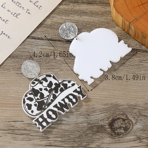 Acrylic cow print cowboy hat earrings with Howdy text in a retro western style