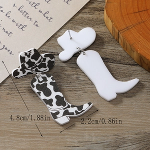 Detail of cow print acrylic cowboy boot and hat earrings with 4.8cm length dimension