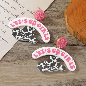 Close-up of pink glitter earrings with Let's Go Girls text and cow print cowboy hats