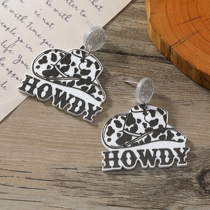 Detail of cow print acrylic cowboy hat earrings with Howdy text and silver glitter studs